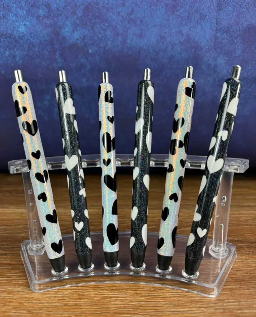 Black and holographic heart pens on display