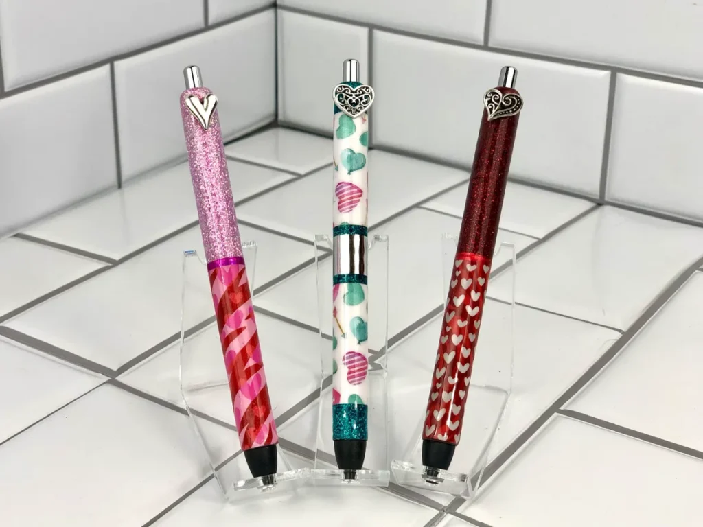 Three pens are sitting on a tile floor.