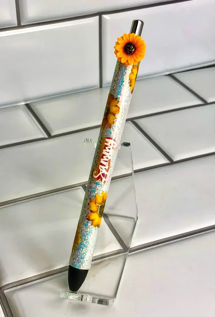 A pencil with an orange flower on it.
