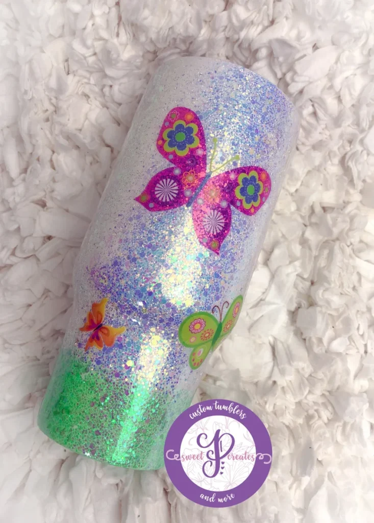 A close up of a candle with butterflies on it