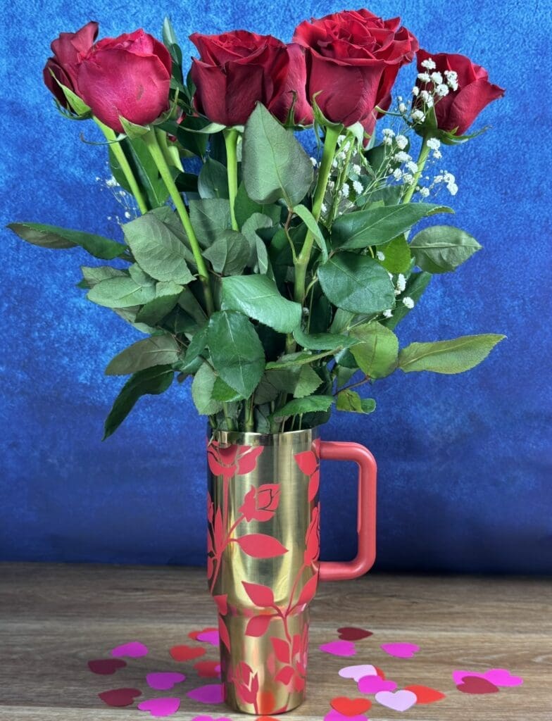 Red roses in a decorative metal vase.