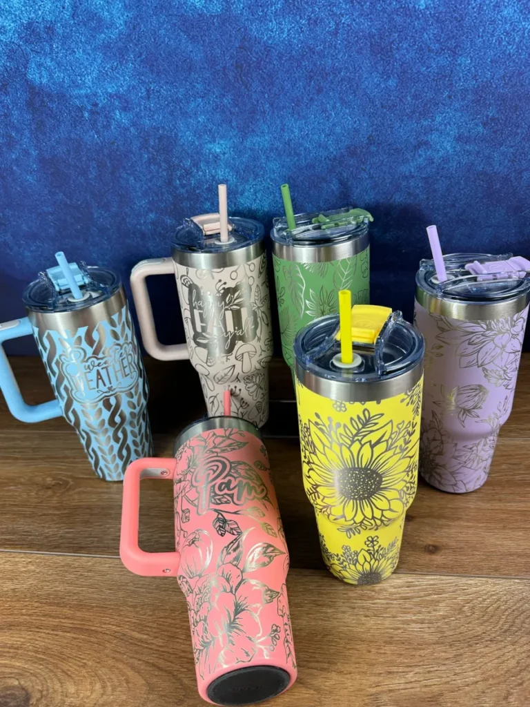 A group of six cups with straws in them.