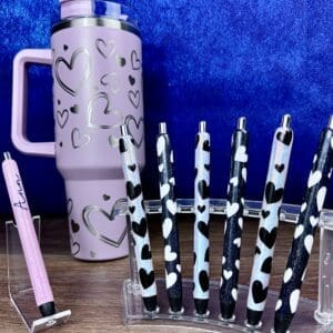 Pink tumbler and decorative heart pens.