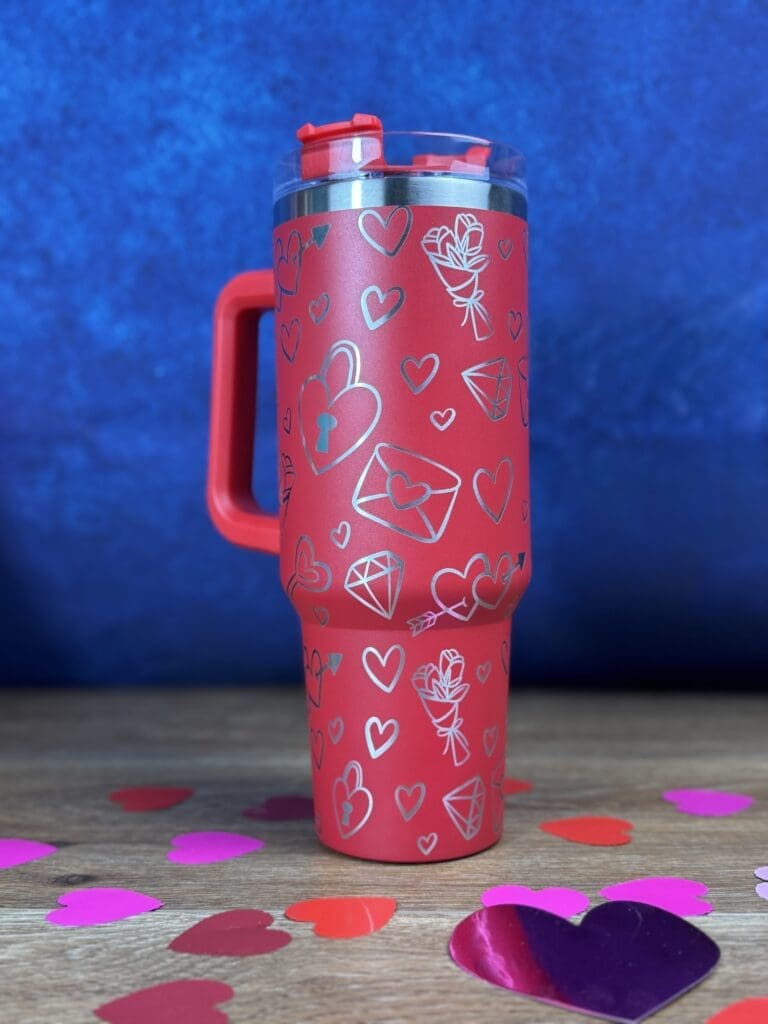 Red cup with heart designs and confetti.