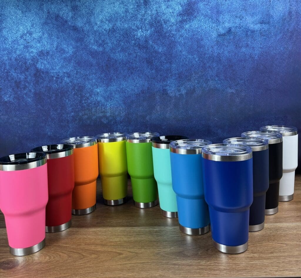 Colorful tumblers arranged on a wooden surface.
