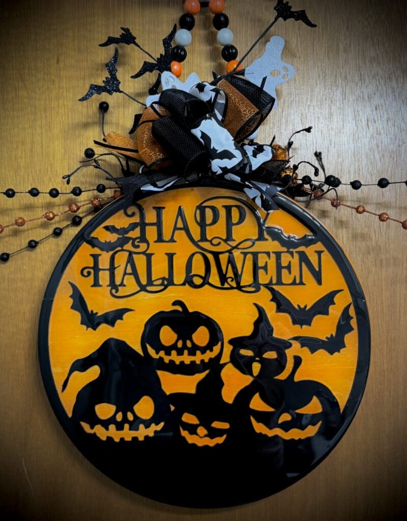 Halloween sign with pumpkins and bats.