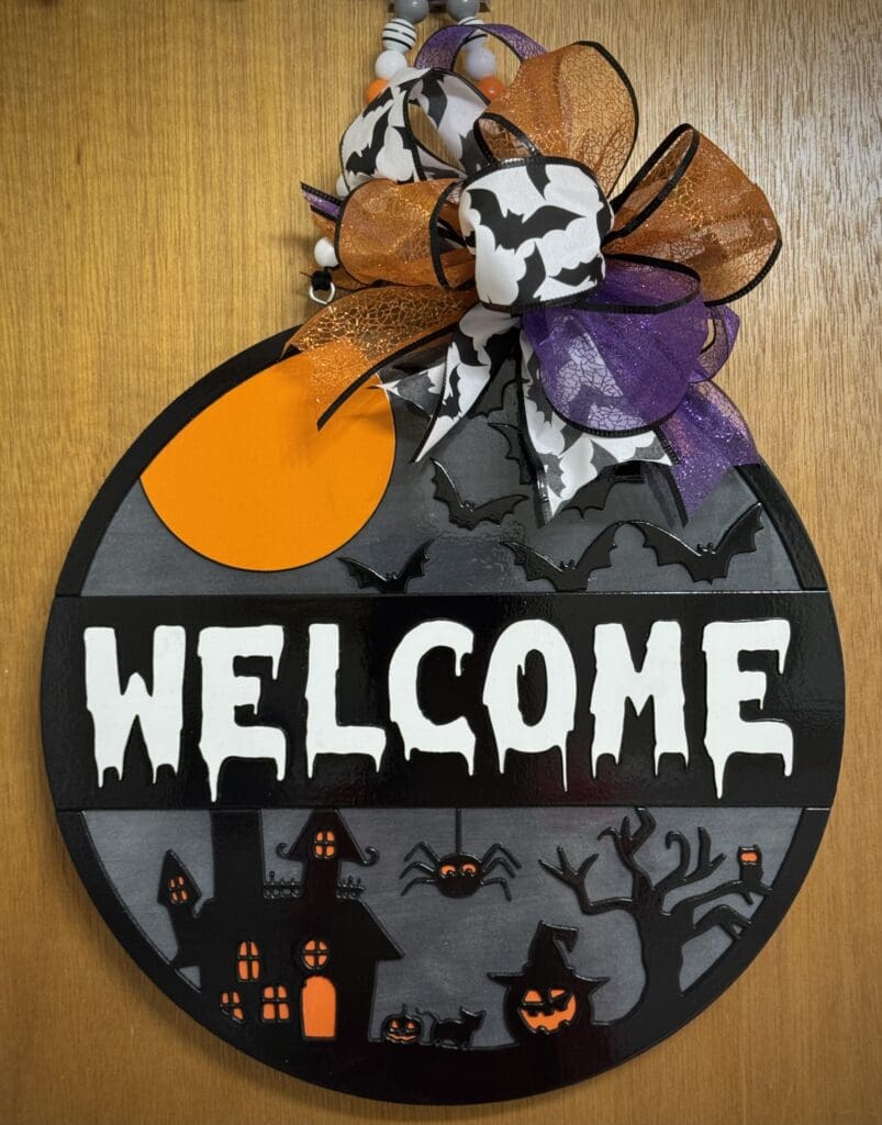 Halloween-themed welcome sign with bats and ribbons.