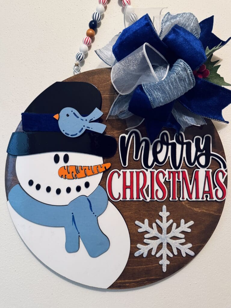 Snowman Christmas decoration with blue ribbon.