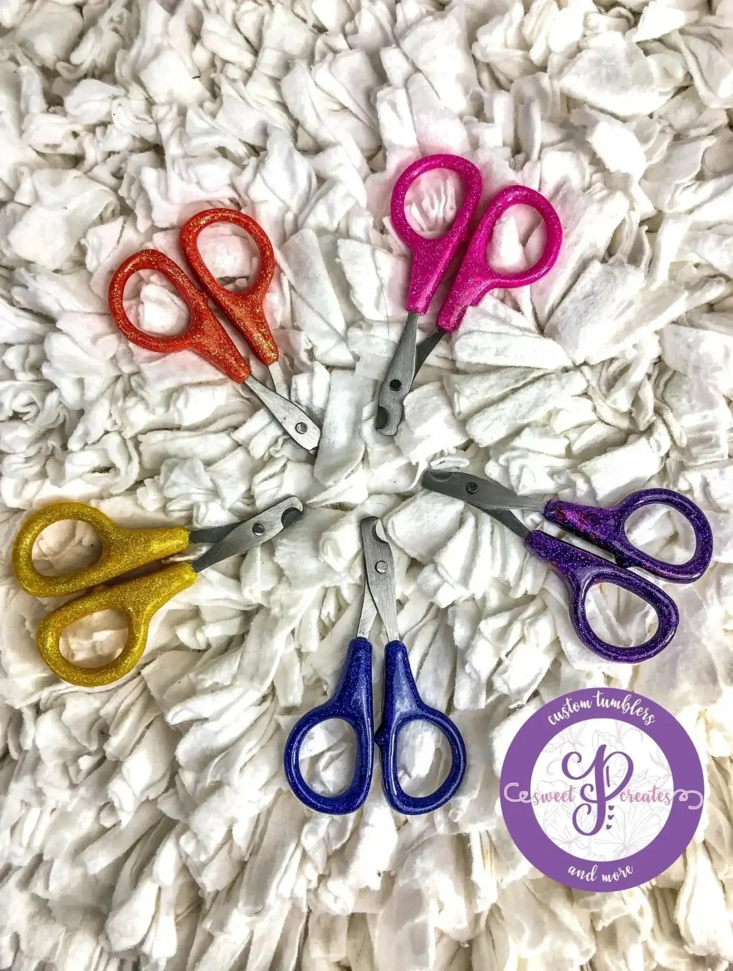 Colorful scissors arranged on a white background.