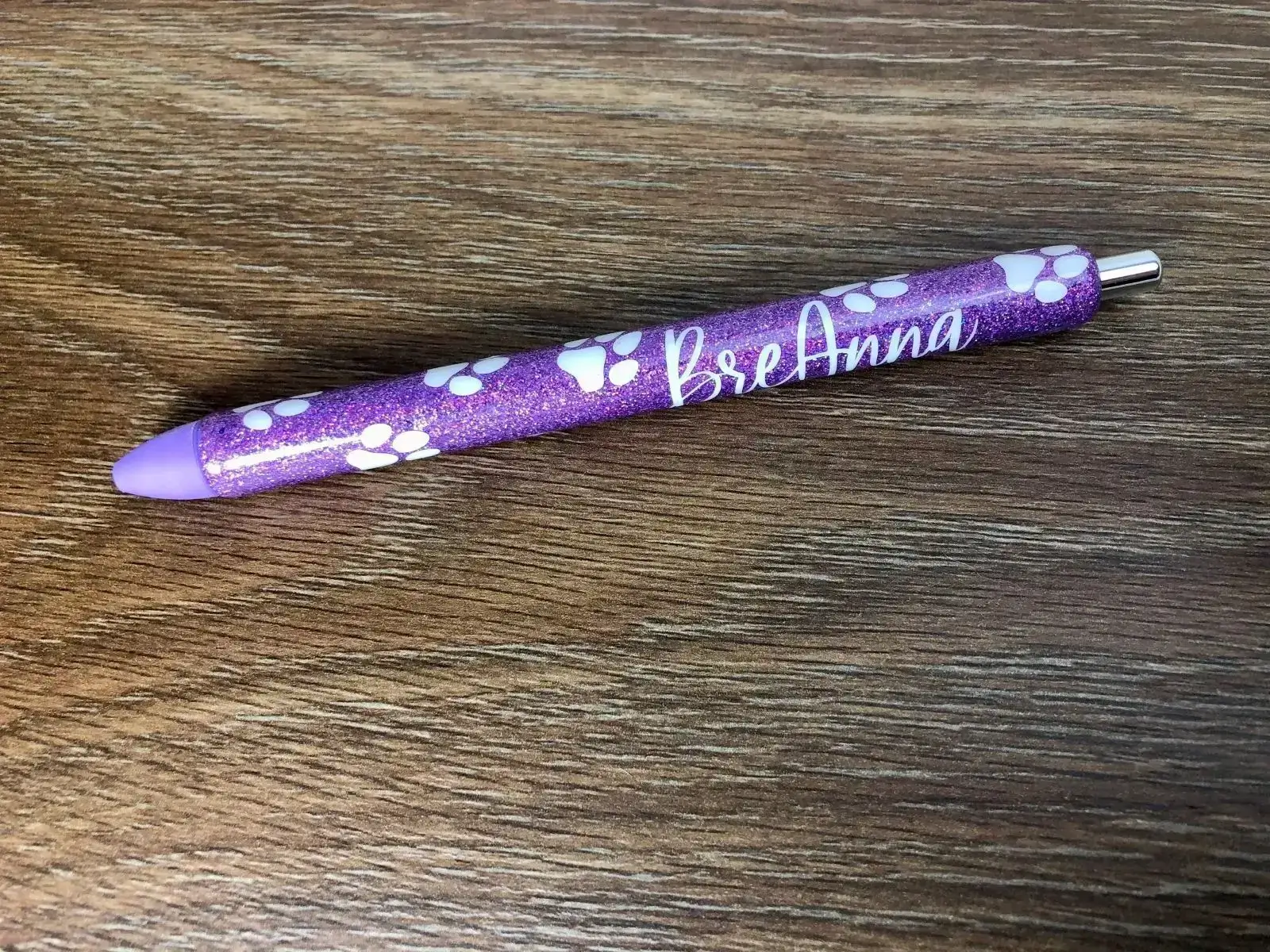 Purple glitter pen with white paw prints.