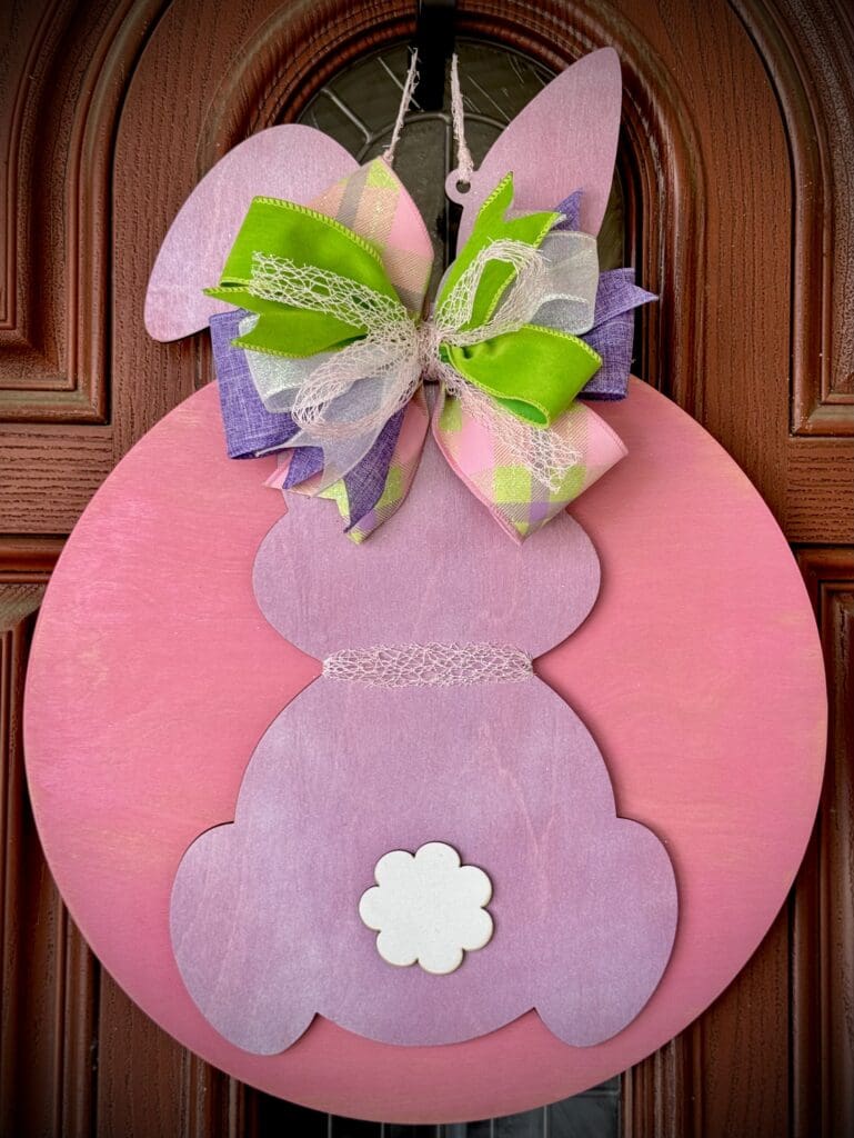 Pink bunny door decoration with colorful bow.