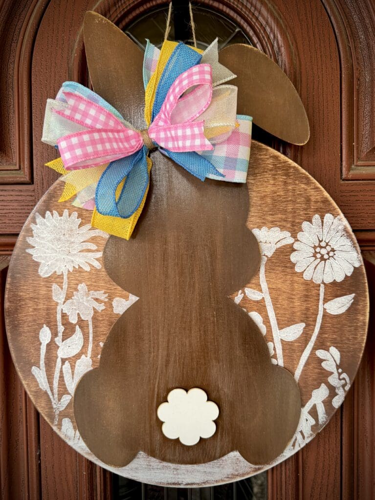 Wooden bunny decor with colorful bow.