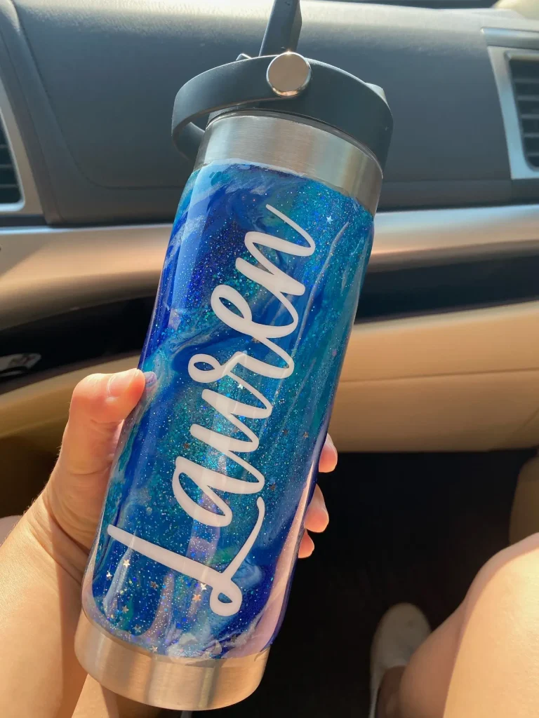 Personalized blue glitter water bottle in hand.