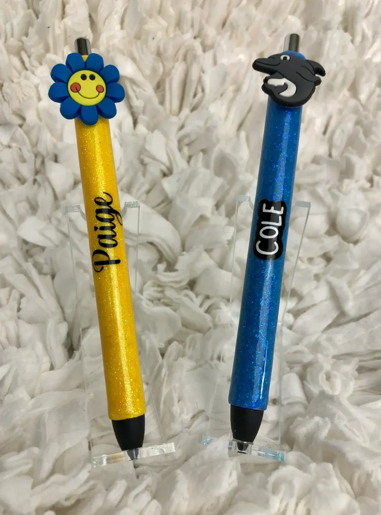 Colorful pens with decorative tops displayed.