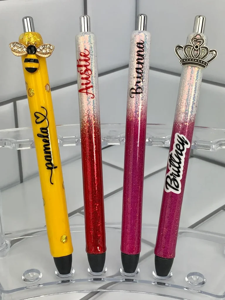 Colorful personalized pens with decorative tops.